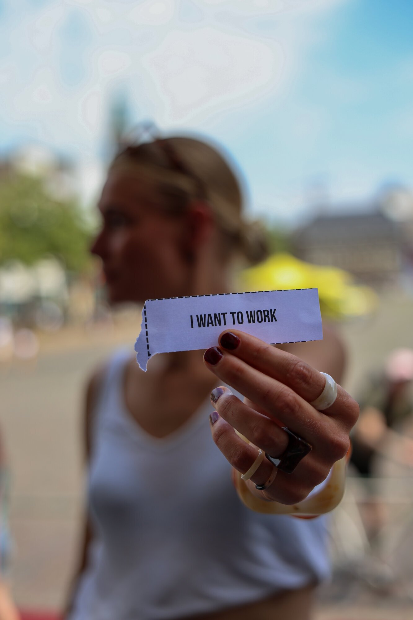 Iemand houdt een strookje papier omhoog met de tekst I want to work